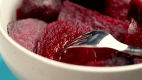Dietary cooked boiled red beets with a steel fork in a ceramic bowl on a colored blue background. Rotation - Powered by Shutterstock - Get 15% off with code: PIKWIZARD15