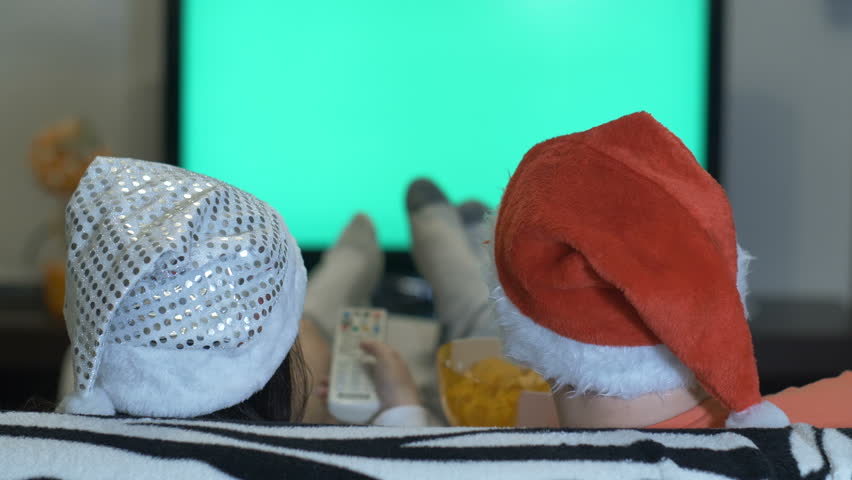 woman with a man in Christmas hats watching TV, hromakey