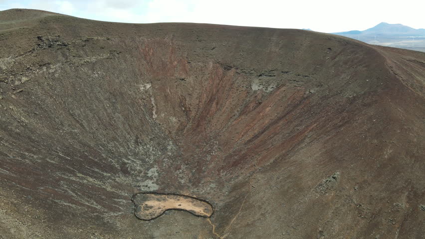 Aerial view descending into Bayuyo volcano crater rugged Fuerteventura Las Palmas landmark