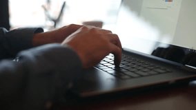 Camera slides around freelancer's hands typing on laptop keyboard in slow motion. Businessman working at office with internet. Man searches new job on internet at coffeeshop. Business concept.