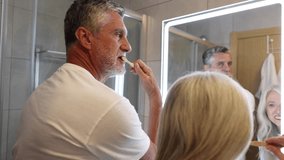 retired couple brushing their teeth together in the bathroom - Powered by Shutterstock - Get 15% off with code: PIKWIZARD15