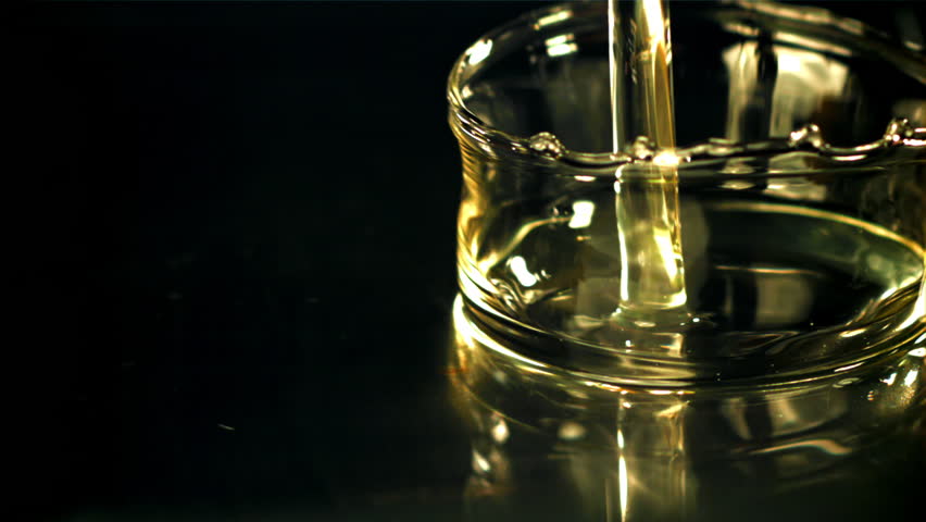Olive oil with splashes on black background. Filmed on a high-speed camera at 1000 fps. High quality FullHD footage