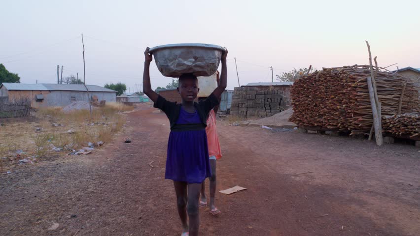Front view of children working as child labor during evening in Wulugu Village in Ghana.