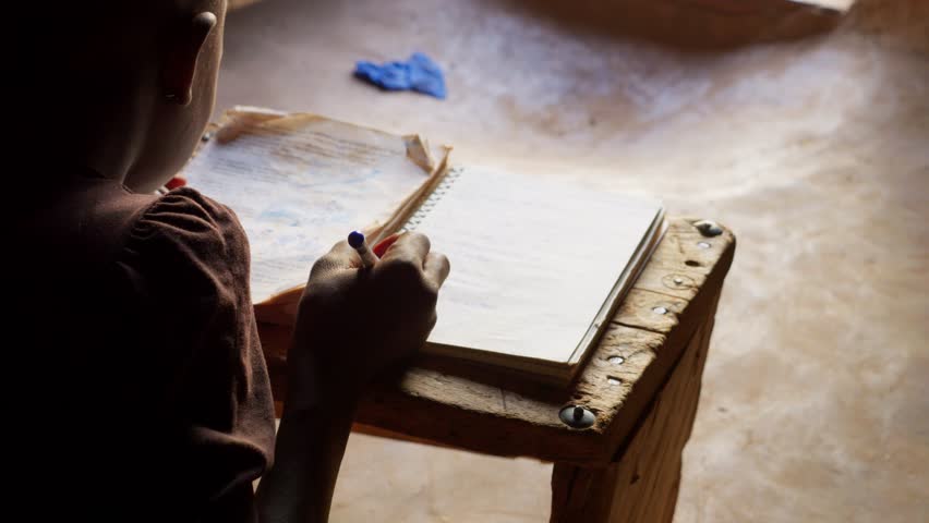 black african children kid study alone writing on notebook preparing homework for school in remote village of Africa
