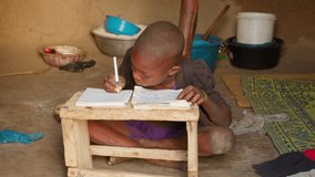 african instruction school concept black child kid studying alone writing on notebook in his house in remote village - Powered by Shutterstock - Get 15% off with code: PIKWIZARD15
