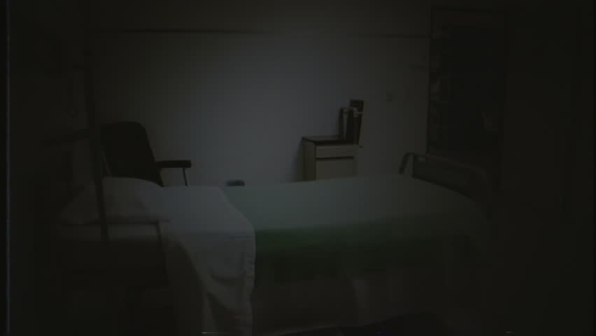 Empty Hospital Bed Moonlight VHS Effect Tracking Shot. Camera walking inside hospital room at night with moonlight over an empty bed, old VHS effect. Tracking shot