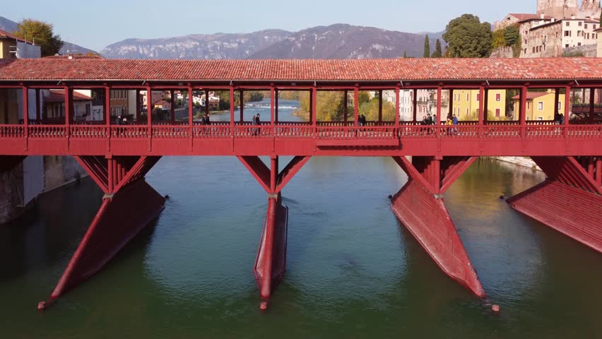 AERIAL: Bassano del Grappa historic wooden bridge cinematic aerial view in a sunny day. Veneto, Italy. Royalty-Free Stock Footage #3432035063