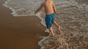 Summer beach holidays. Carefree, happy small child having fun running barefoot along ocean coast at sunset. - Powered by Shutterstock - Get 15% off with code: PIKWIZARD15