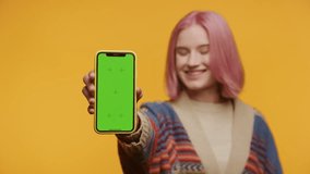 Cheerful Pink Hair Woman Showing Green Screen Smartphone