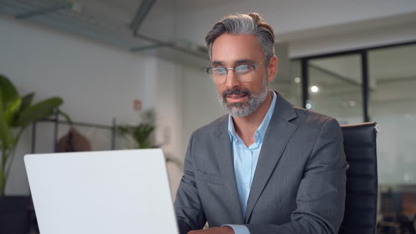 Focused mature European business man ceo trader using computer, typing, working in modern office, doing online data market analysis, thinking planning tech strategy looking at laptop with copy space. Royalty-Free Stock Footage #3432134629