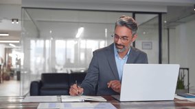 Middle-age Hispanic man using laptop computer for business studying, watch online virtual webinar training meeting, video call. Focused mature Indian or Latin businessman work in office, copy space.