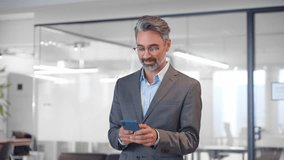 Close-up of focused mature Latin or Indian businessman holding smartphone in office. Middle aged manager using cell phone mobile app. Digital technology application and solutions for business concept. - Powered by Shutterstock - Get 15% off with code: PIKWIZARD15