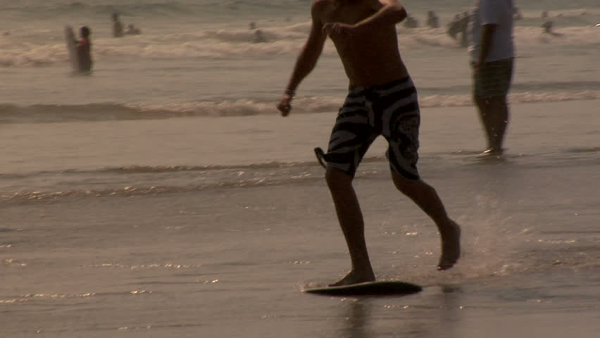 Skimboarder in slow motion at the beach