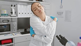 Cheerful young hispanic woman in scientist uniform hugging herself confidently in lab. smiling, expressing happiness, self love and positive vibes at the laboratory. - Powered by Shutterstock - Get 15% off with code: PIKWIZARD15