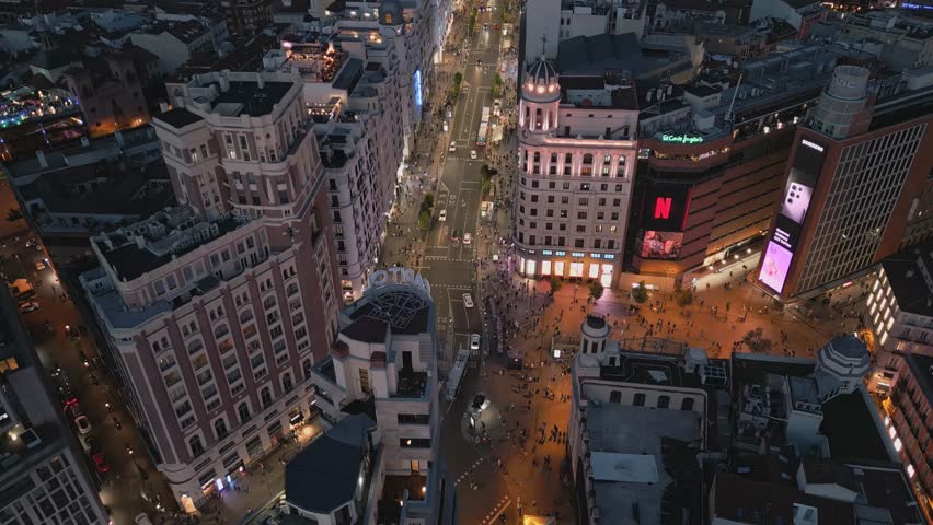 Madrid, Spain -8.12.2023: Establishing aerial view of Madrid Gran Via historic buildings architecture and cars driving on the road at night, Madrid Spain tourism attractions