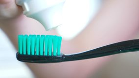 Squeezing toothpaste from a tube onto a toothbrush. Macro, close-up 4k. slow motion, copy space - Powered by Shutterstock - Get 15% off with code: PIKWIZARD15