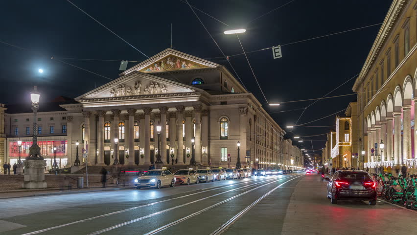 Munich National Theatre or Nationaltheater on the Max Joseph square night timelapse. Traffic on the street with trams and taxi parking. Historic opera house, home of the Bavarian State Opera. Germany Royalty-Free Stock Footage #3432285021