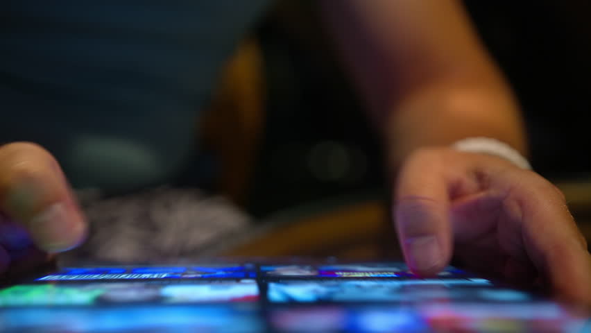 Top view modern tech device bright screen 4K. Young man scrolling content online, wireless internet. Closeup male hands searching on tablet screen, browsing videos, images content using WiFi at night 