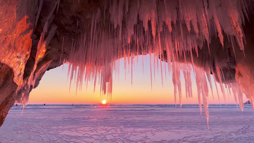 Frozen winter lake Baikal, Siberia, Russia. Ice icicles and blocks in the rocks, grottoes and caves at dawn. Natural background of cold ice. Winter abstract background. High quality 4k footage