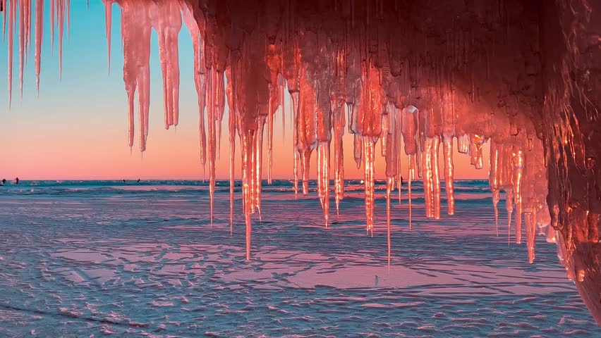 Frozen winter lake Baikal, Siberia, Russia. Ice icicles and blocks in the rocks, grottoes and caves at dawn. Natural background of cold ice. Winter abstract background. High quality 4k footage