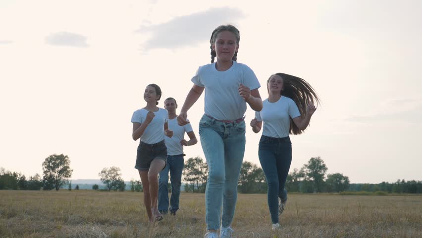 A happy family runs in the park at sunset. A team of people running together. Family dad mom and happy kids have fun weekends. Happy children Royalty-Free Stock Footage #3432326193