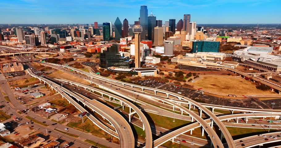 Movement on the highways around the downtown of Dallas, Texas, USA. Sunny panorama of metropolis from air.