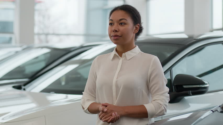 Portrait of African American woman girl customer business client buyer in modern luxurious auto shop buy new automobile in car showroom female seller dealer businesswoman smiling in dealership salon Royalty-Free Stock Footage #3432394099