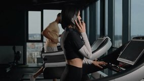 Caucasian woman sporty girl talk mobile phone in gym athletic female sportswoman walk on treadmill cardio exercise talking with smartphone. Multiracial sport people training running in fitness club - Powered by Shutterstock - Get 15% off with code: PIKWIZARD15
