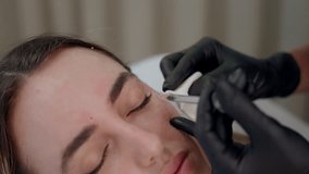 young woman getting beauty injection in cosmetic clinic. Close up cosmetologist doing botox injection in forehead to patient in beauty clinic. Rejuvenation, injectable cosmetology and medicine concept - Powered by Shutterstock - Get 15% off with code: PIKWIZARD15