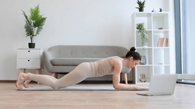 Beautiful calm yogini in beige activewear improving body strength while holding Side Plank Pose with lifted leg. Healthy senior female practising modern yoga with Vasisthasana exercise at home.