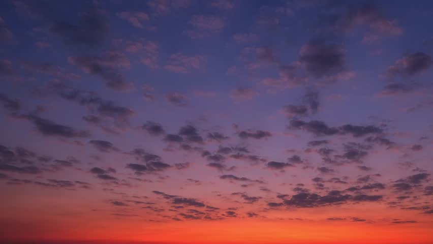 4K : Sunrise sky time lapse - Timelapse video captures a sunrise sky adorned with layers of ethereal clouds, transforming the horizon into a vibrant canvas painted with hues of gold, pink, and orange.