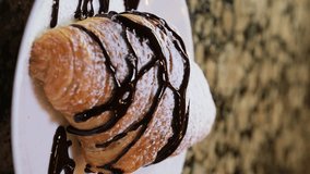 drop of chocolate syrup hot chocolate slowly flows over a freshly baked croissant black background chocolate pastry chocolate croissant bun french dessert sweetness topping