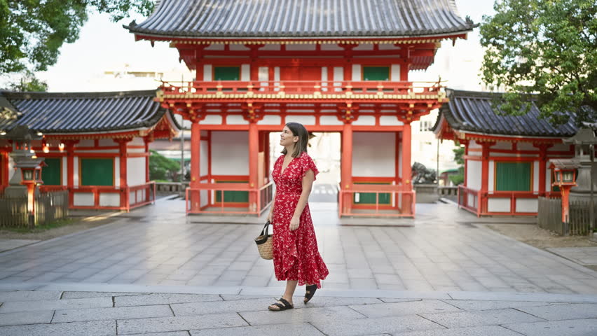 Cheerful beautiful hispanic woman enjoying the traditional grandeur of yasaka shrine, joyfully posing and smiling while looking around at the picturesque kyoto temple surroundings. Royalty-Free Stock Footage #3432544551