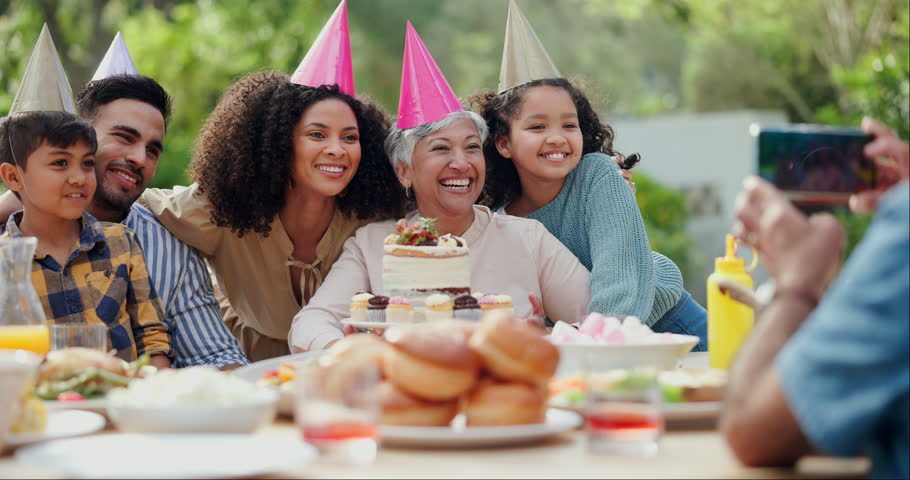 Family, birthday party and people with phone for photo in garden with cake, happy and love. Grandmother, parents and children with smartphone for memory, dessert and home in backyard on social media