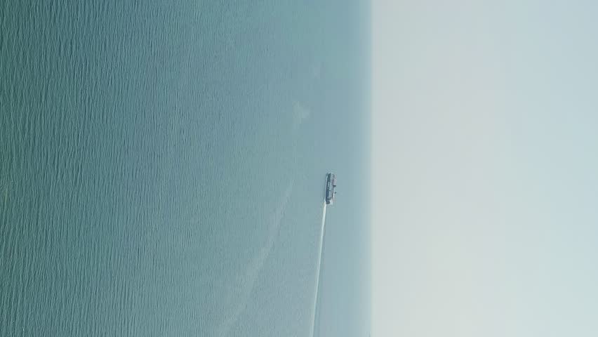Vertical video. Kavala, Greece. Kavala Fortress. The ferry leaves the port. Historic city center. Aegean Sea. Summer, Aerial View, Departure of the camera