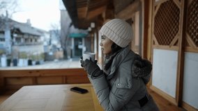 Slow-motion video of a Filipino woman in her 20s taking a break after drinking tea in a traditional town at the North Village Hanok Village in Seoul, Republic of Korea