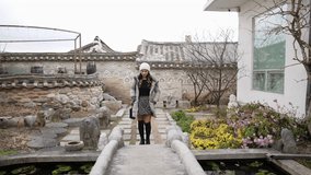 Slow-motion video of a Filipino woman in her 20s strolling through a traditional townscape in Bokchon Hanok Village in Seoul, Republic of Korea