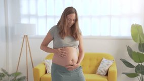 Happy pregnant women touching her belly relaxed . High quality 4k footage - Powered by Shutterstock - Get 15% off with code: PIKWIZARD15