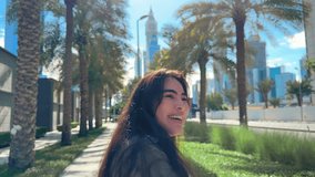 happy girl with long hair in the city overlooking high-rise buildings, high quality vertical video 4k resolution