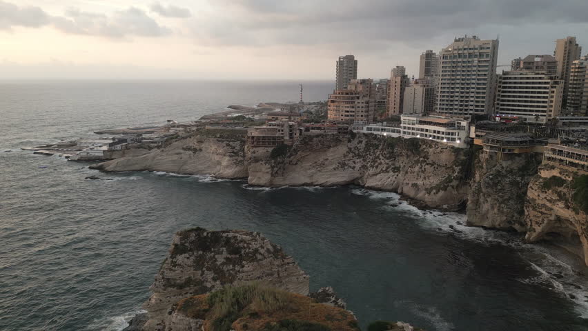 Aerial footage gracefully descends upon the rocky Mediterranean coastline of Beirut, Lebanon Royalty-Free Stock Footage #3432752859
