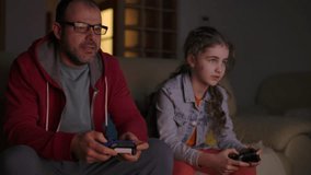 Father and Daughter Expressing Emotions While Enjoying Relaxing Together, Playing Video Games in Front of TV. Family Time Hobby. Family Having Fun Together at Home in Living Room Playing Video Games.