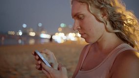 Thailand, Pattaya, close-up video on the beach of a young girl typing on her phone. 4k video