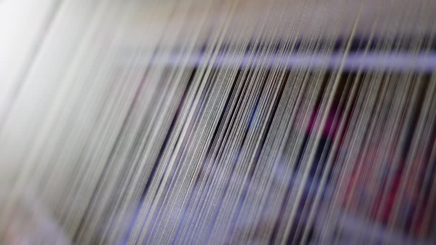 View of silk thread lined up in traditional silkworm spinning machine.