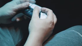 Male hands using gamepad joystick controller to play video game. Claw grip.
