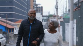 Genuine Family Care - African American Man in 50s and His 80-Year-Old Mother Walking Together in City conversing, Embodying Love and Support in Senior Years - Powered by Shutterstock - Get 15% off with code: PIKWIZARD15