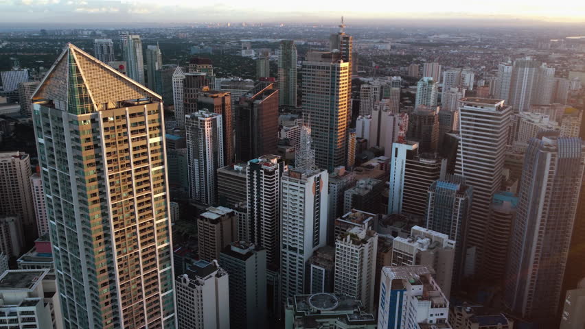 Aerial overview of the City of Makati, financial center of Manila, Philippines - pull back, drone shot