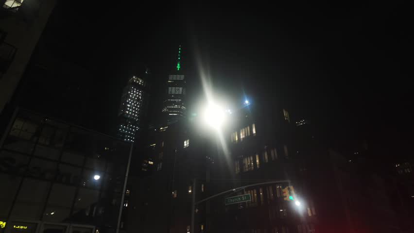POV shot looking up on illuminated skyscrapers while driving in New York, USA