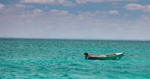 Wooden fishing speed boat on a sunny day floating in the calm turquoise water of caribbean sea