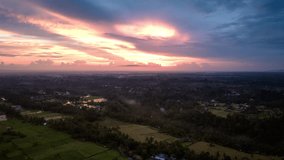 Hyperlapse timelapse of sunset with bright and colorful sky over Indonesian Ubud village, Bali. Aerial forward