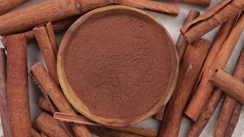 cinnamon powder and sticks in bowl top view spice